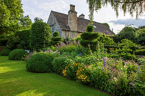 GREYHOUNDS_BURFORD_OXFORDSHIRE_THE_CROQUET_LAWN_BORDER_WITH_HORNBEAM_SCREEN_AND_YEW_AND_BOX_TOPIARY_