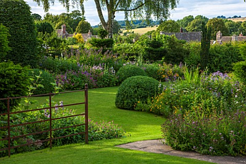GREYHOUNDS_BURFORD_OXFORDSHIRE_COUNTRY_COTTAGE_GARDEN_SCENE_WITH_LAWN_AND_HERBACEOUS_BORDERS_WITH_VI