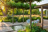 PRIVATE GARDEN, GLOUCESTERSHIRE DESIGNED BY MARCUS BARNETT: RILL, CANAL, PLEACHED TREES, SEATS, SITIING, SUMMER, COUNTRY, GARDEN, COTSWOLDS
