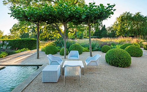 PRIVATE_GARDEN_GLOUCESTERSHIRE_DESIGNED_BY_MARCUS_BARNETT_TABLES_CHAIRS_CLIPPED_TOPIARY_DOMES_GRAVEL