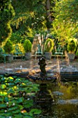 EASTLEACH HOUSE, GLOUCESTERSHIRE:LILY POND, CHERUB FOUNTAIN,  SCULPTURE, EVENING LIGHT. COUNTRY GARDEN, ENGLISH, WATER, POOL, POND