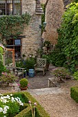 CALENDARS: BURFORD,OXFORDSHIRE: CORNER OF BOX PARTERRE TO LOWER TERRACE WITH POTTED PELARGONIUMS, AGAPANTHUS & ROSEMARY. FIG ON RIGHT-HAND WALL.CHAIRS,A PLACE TO SIT,GARDEN,SUMMER