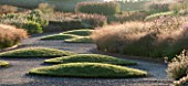 HAUSER & WIRTH, SOMERSET: THE OUDOLF FIELD, DURSLADE FARM - MIST, GRAVEL PATH PAST GRASS MOUNDS AND NEW PERENNIAL BORDERS BY PIET OUDOLF - SUNRISE, DAWN, LAWN