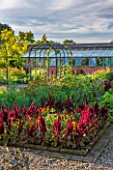 MORTON HALL GARDENS, WORCESTERSHIRE: KITCHEN GARDEN IN LATE SUMMER. GREENHOUSE, THE HALL, BEDS WITH DARK RED AMARANTHUS. WALL, WALLED, COUNTRY, HOUSE, CLASSIC, VEGETABLE, SKY