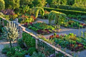 MORTON HALL GARDENS, WORCESTERSHIRE: VIEW KITCHEN GARDEN IN LATE SUMMER. BEDS WITH AMARANTHUS, CALENDULA. WALL, WALLED, COUNTRY, HOUSE, CLASSIC, VEGETABLE, ARCH, DAHLIAS, DARK, RED