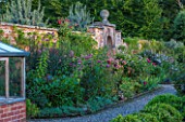MORTON HALL GARDENS, WORCESTERSHIRE: KITCHEN GARDEN. LILIUM SPECIOSUM BLACK BEAUTY AND CLEMATIS VITICELLA EMILIA PLATER. BULB, CLIMBER, CLIMBERS, WALL, WALLED, BORDER, BED