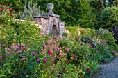 MORTON HALL GARDENS, WORCESTERSHIRE: KITCHEN GARDEN. LILIUM SPECIOSUM BLACK BEAUTY AND CLEMATIS VITICELLA EMILIA PLATER. BULB, CLIMBER, CLIMBERS, WALL, WALLED, BORDER, BED