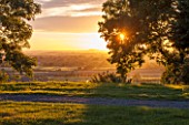 MORTON HALL GARDENS, WORCESTERSHIRE: WEST GARDEN TERRACE, SUNSET, EVENING LIGHT, VIEW WEST TO ABBERLY HILLS, CLOUDS, SKY, DRAMATIC