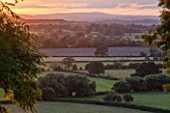 MORTON HALL GARDENS, WORCESTERSHIRE: WEST GARDEN TERRACE, SUNSET, EVENING LIGHT, VIEW WEST TO ABBERLY HILLS, CLOUDS, SKY, DRAMATIC