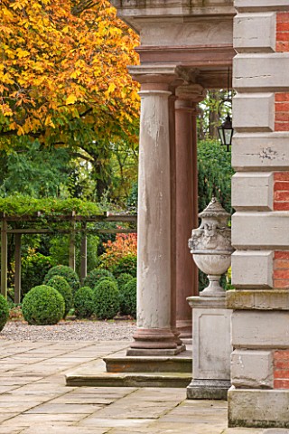 MORTON_HALL_WORCESTERSHIRE_DETAIL_OF_SANDSTONE_COLUMNS_AND_LIDDED_URNS_WITH_BOX_BALLS_AND_TREE_IN_AU