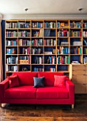 MORTON HALL, WORCESTERSHIRE: READING ROOM WITH OAK BOOKSHELVES AND RED SOFABED JAMES