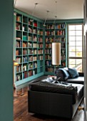 MORTON HALL, WORCESTERSHIRE: LIBRARY WITH SHELVES BY WIENER WERKSTAETTEN, PAINTED IN FB DIX BLUE. DOORS OUT ONTO SOUTH GARDEN. CYLINDER LAMP AND BLACK LEATHER SOFA