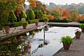 BORDE HILL GARDEN, WEST SUSSEX. AUTUMN. OCTOBER, FALL. THE ITALIAN GARDEN WITH TERRACOTTA CONTAINERS, FOUNTAIN AND POOL. POND, WATER