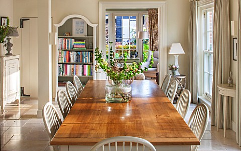 THE_COACH_HOUSESURREYBREAKFAST_ROOM_WITH_LARGE_TABLE__CHAIRS_MANDARIN_STONE_FLOOR_BOOKCASE_DEMI_LUNE