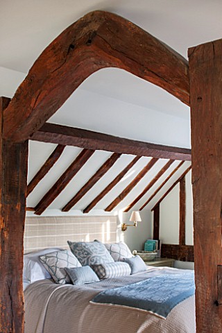 THE_COACH_HOUSESURREY_BEDROOM_WITH_DETAIL_OF_WOODEN_BEAMS_CUSHIONS_AND_BED_COVER_BY_HUDSON_HOMES__IN