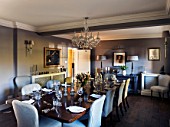 THE COACH HOUSE,SURREY: DINING ROOM. CHANDELIER BY INDIA JANE,CONSOLE TABLE & LAMPS BY MARGARET BOYD, DARK WOOD TABLE & FABRIC CHAIRS FROM HUDSON HOMES & INTERIORS.ENTERTAINING.