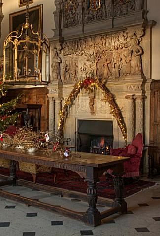 BURTON_AGNES_HALL_EAST_YORKSHIRE_CHRISTMAS___GREAT_HALL_LONG_OAK_TABLE_DECORATED_WITH_BRANCHES_AND_G