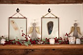 THE FREETH, HEREFORDSHIRE: KITCHEN, DINER - ANGELS, BERRIES AND GLASS FRAMED FEATHER HANGINGS ON MANTELPIECE. CHRISTMAS, DECORATIONS