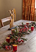THE FREETH, HEREFORDSHIRE: KITCHEN, DINER - WOODEN TABLE WITH BERRY DECORATION, CANDLES, GOLDEN ANGEL CANDLE HOLDERS. CHRISTMAS