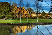 ABLINGTON MANOR, GLOUCESTERSHIRE: VIEW ACROSS RIVER COLN TO MANOR HOUSE. MARCH, EARLY SPRING, LATE WINTER, WATER, RIVER, COUNTRY, GARDEN, ENGLISH, TOPIARY