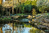 MORTON HALL GARDENS, WORCESTERSHIRE: THE STROLL GARDEN IN MARCH. REFLECTIONS, REFLECTED, ROCKERY, ROCKS, SUNRISE, SPRING