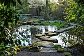 MORTON HALL, WORCESTERSHIRE: SPRING. STEPPING STONES, POND, REFLECTION OF BIRCH TREES ACROSS THE WATER. POOL, REFLECTIONS, REFLECTED, WOODLAND, ROCK, ROCKS