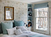 LONDON HOUSE DESIGNED BY JULIE SIMONSEN. BLUE BEDROOM WITH ANTIQUE PAINTING ON WALL. WALLPAPER BY COLEFAX & FOWLER