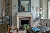 LONDON HOUSE DESIGNED BY JULIE SIMONSEN. THE LIVING ROOM IN SHADES OF BLUE WITH NEW SANDSTONE FIRE SURROUND. DISTRESSED BLUE MIRROR AND VINTAGE TRUNK USED AS COFFEE TABLE