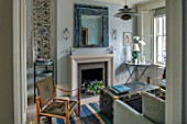 LONDON HOUSE DESIGNED BY JULIE SIMONSEN. THE LIVING ROOM IN SHADES OF BLUE WITH NEW SANDSTONE FIRE SURROUND. DISTRESSED MIRROR AND VINTAGE TRUNK USED AS COFFEE TABLE
