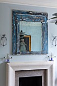 LONDON HOUSE DESIGNED BY JULIE SIMONSEN. DISTRESSED BLUE MIRROR OVER FIREPLACE IN LIVING ROOM.