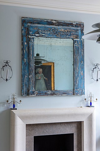LONDON_HOUSE_DESIGNED_BY_JULIE_SIMONSEN_DISTRESSED_BLUE_MIRROR_OVER_FIREPLACE_IN_LIVING_ROOM