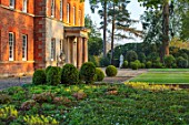 MORTON HALL GARDENS, WORCESTERSHIRE: THE FRONT OF THE HALL WITH BOX TOPIARY SHAPES - DAWN LIGHT, MORNING, ENGLISH, GARDEN, CLASSIC, TOPIARY, SPRING, STATUE, STAUARY, FORMAL