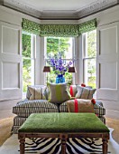 DESIGNER BUTTER WAKEFIELD, LONDON - THE FRONT ROOM - SETTEE WITH WINDOW AND BLUE CONTAINER WITH BLUE DELPHINIUMS