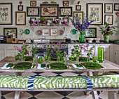 BUTTER WAKEFIELD HOUSE, LONDON: THE KITCHEN - TABLE SET WITH GREEN PLATES AND FLOWERS FROM THE GARDEN IN GLASS VASES. INDOORS, INSIDE