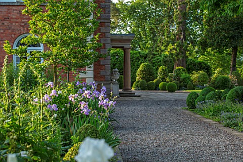 MORTON_HALL_WORCESTERSHIRE_GRAVEL_PATH_SOUTH_GARDEN_CLIPPED_YOPIARY_BOX_LAWN_IRISES_SUMMER_SPRING_HE