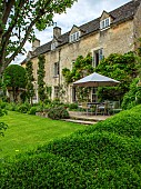 THE LODGE, OXFORDSHIRE: DESIGNER SUSAN ASHTON. VIEW OF THE HOUSE IN SUMMER WITH LAWN, TABLE AND CHAIRS & PARASOL. CLASSIC COUNTRY GARDEN, TRADITIONAL COTTAGE STYLE PLANTING