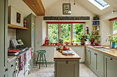 THE LODGE, OXFORDSHIRE: DESIGNER SUSAN ASHTON. THE KITCHEN INTERIOR WITH WOODEN UNITS, ISLAND AND SKYLIGHT