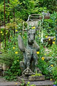 THE LODGE, OXFORDSHIRE: DESIGNER SUSAN ASHTON. RAMBLING GARDEN WITH STONE DRAGON STATUE WITH WELSH POPPIES AND FOXGLOVES. INFORMAL, COUNTRY GARDEN.