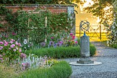 MOTTISFONT ABBEY, HAMPSHIRE: THE NATIONAL TRUST. ARMILLARY SPHERE IN THE SECOND ROSE GARDEN, SUNSET, EVENING LIGHT, ROSES, GARDENS, SUMMER, WALLS, WALLED, SUNDIAL