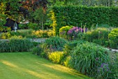 THE OLD RECTORY, QUINTON, NORTHAMPTONSHIRE: DESIGNER ANOUSHKA FEILER: LAWN AND PERENNIAL PLANTING. HEDGE, HEDGES, HEDGING, EVENING LIGHT, SUMMER, JUNE
