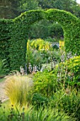 THE OLD RECTORY, QUINTON, NORTHAMPTONSHIRE: DESIGNER ANOUSHKA FEILER: VIEW THROUGH CLIPPED ARCH IN HEDGE. SUMMER, ENGLISH, COUNTRY, GARDEN, GREEN, TOPIARY