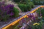 THE OLD RECTORY, QUINTON, NORTHAMPTONSHIRE: DESIGNER ANOUSHKA FEILER: RILL LIT UP AT NIGHT WITH PERENNIAL PLANTING. LIGHTING, WATER, CANAL, LIGHTS