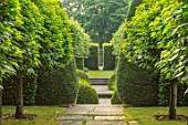 WOLLERTON OLD HALL, SHROPSHIRE: VIEW DOWN LENGTH OF GARDEN PASTYORK STONE PATH, CLIPPED PORTUGUESE LAURELS, YEW, BEECH HEDGES, HEDGING, GREEN, SUMMER