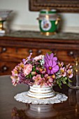 PARHAM, SUSSEX: GREEN ROOM - WHITE AND GOLD CONTAINER WITH PINK ALSTROEMERIA, COSMOS, RHAMNUS, WHITE SALVIA, JOE PYE WEED, PEACH COLOURED ASTER