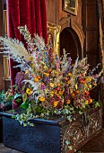 BADDESLEY CLINTON, WARWICKSHIRE: THE NATIONAL TRUST- CHRISTMAS, 15TH AND 16TH CENTURY MOATED MANOR HOUSE. GREAT HALL, ANTIQUE CARVED OAK CHEST, DRIED FLOWER ARRANGEMENT