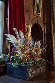 BADDESLEY CLINTON, WARWICKSHIRE: THE NATIONAL TRUST- CHRISTMAS, 15TH AND 16TH CENTURY MOATED MANOR HOUSE. GREAT HALL, ANTIQUE CARVED OAK CHEST, DRIED FLOWER ARRANGEMENT