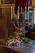 BADDESLEY CLINTON, WARWICKSHIRE: THE NATIONAL TRUST- CHRISTMAS, 15TH AND 16TH CENTURY MOATED MANOR HOUSE. GREAT HALL, CANDLES, DRIED FLOWER ARRANGEMENT