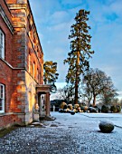 MORTON HALL, WORCESTERSHIRE: WINTER - VIEW OF EAST TERRACE OF HOUSE WITH CLIPPED TOPIARY BOX BALLS, FROST, SNOW, COLD, DECEMBER, ENGLISH, COUNTRY, GARDEN, SUNRISE, DAWN, LIGHT