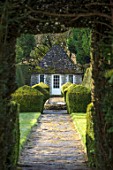 RODMARTON MANOR, GLOUCESTERSHIRE, WINTER - PATH WITH STONE SUMMERHOUSE AND YEW TOPIARY HEDGES. ENGLISH, COUNTRY, GARDEN, FEBRUARY, HEDGING, FORMAL