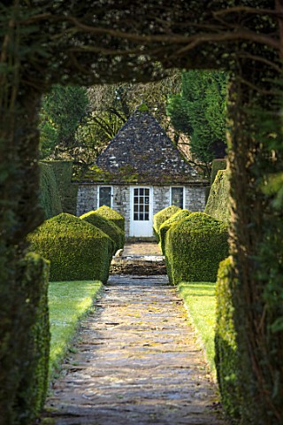 RODMARTON_MANOR_GLOUCESTERSHIRE_WINTER__PATH_WITH_STONE_SUMMERHOUSE_AND_YEW_TOPIARY_HEDGES_ENGLISH_C
